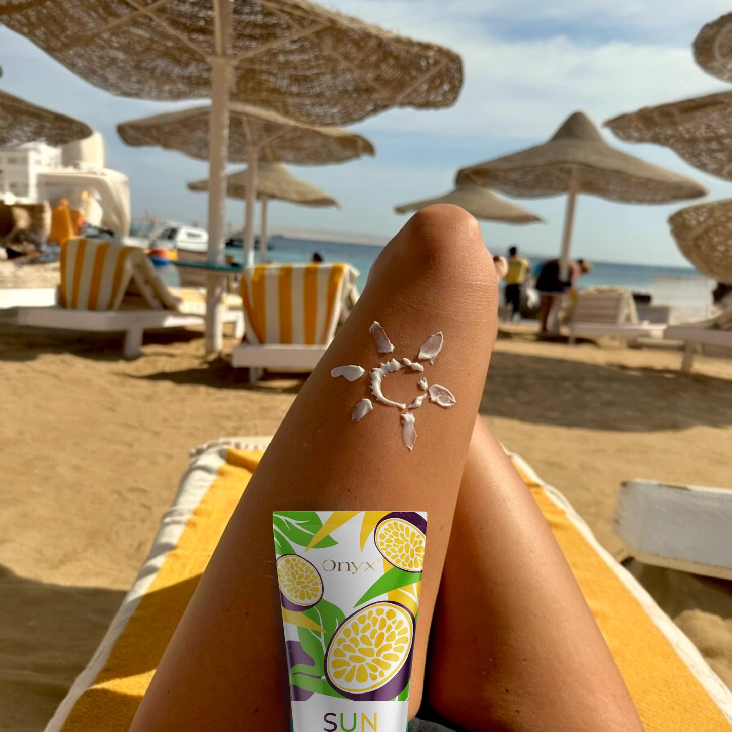 Acelerador de bronceado Onyx Suncolada mostrado sobre pierna bronceada con dibujo solar de crema, diseñado para bronceado al aire libre con aceites naturales y fórmula vegana de rápida absorción