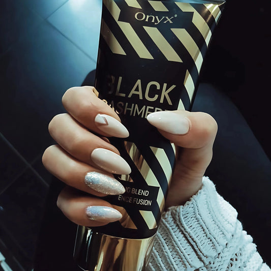 Primer plano de una mano con uñas pintadas y loción bronceadora