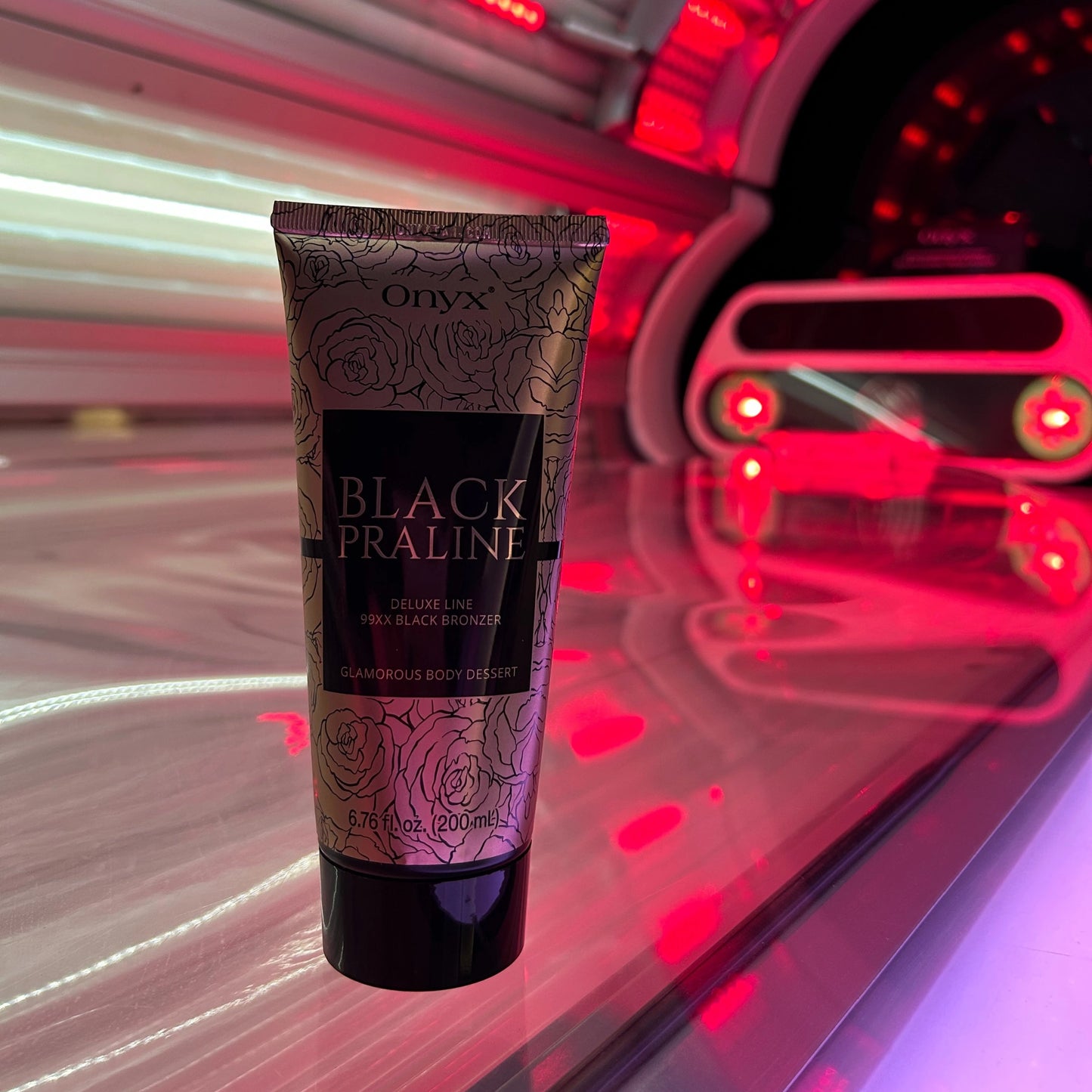 Loción bronceadora Onyx Black Praline sobre una tumbona en solarium con iluminación roja