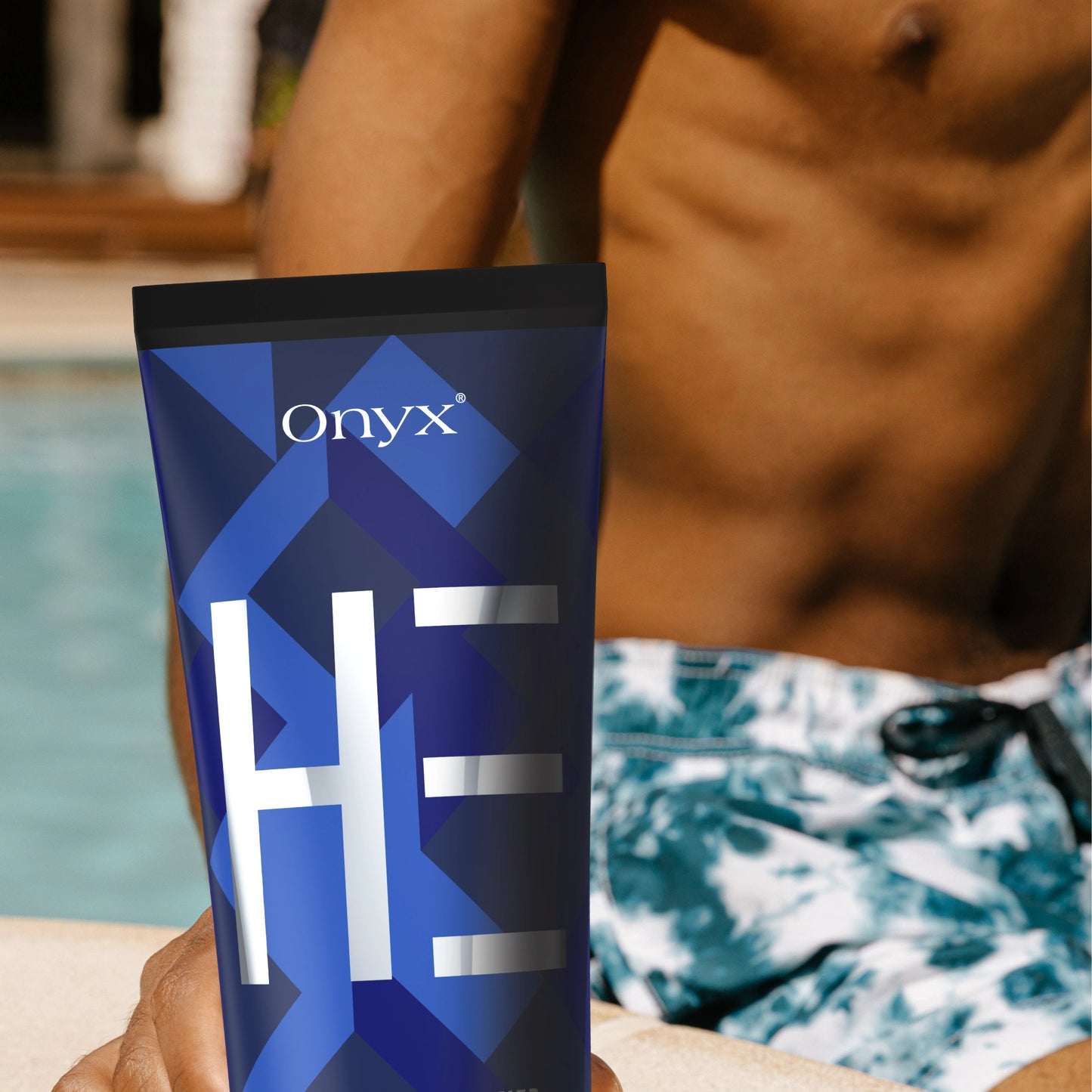 Loción bronceadora masculina Onyx HE junto a una piscina: bronceador de rápida absorción para una piel besada por el sol.