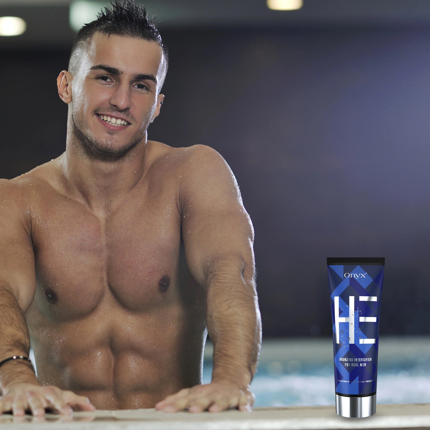 Hombre sonriendo en un salón de bronceado sosteniendo Onyx HE Bronzing Lotion: acelerador de bronceado profesional para hombres.
