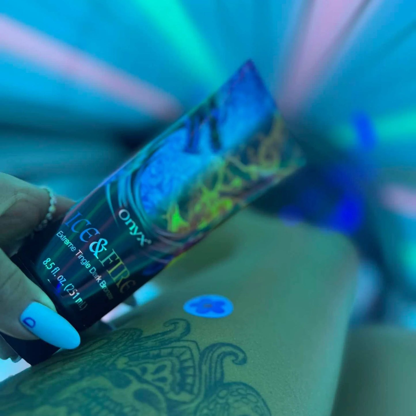Ice & Fire loción bronceadora en pierna tatuada durante sesión de solarium