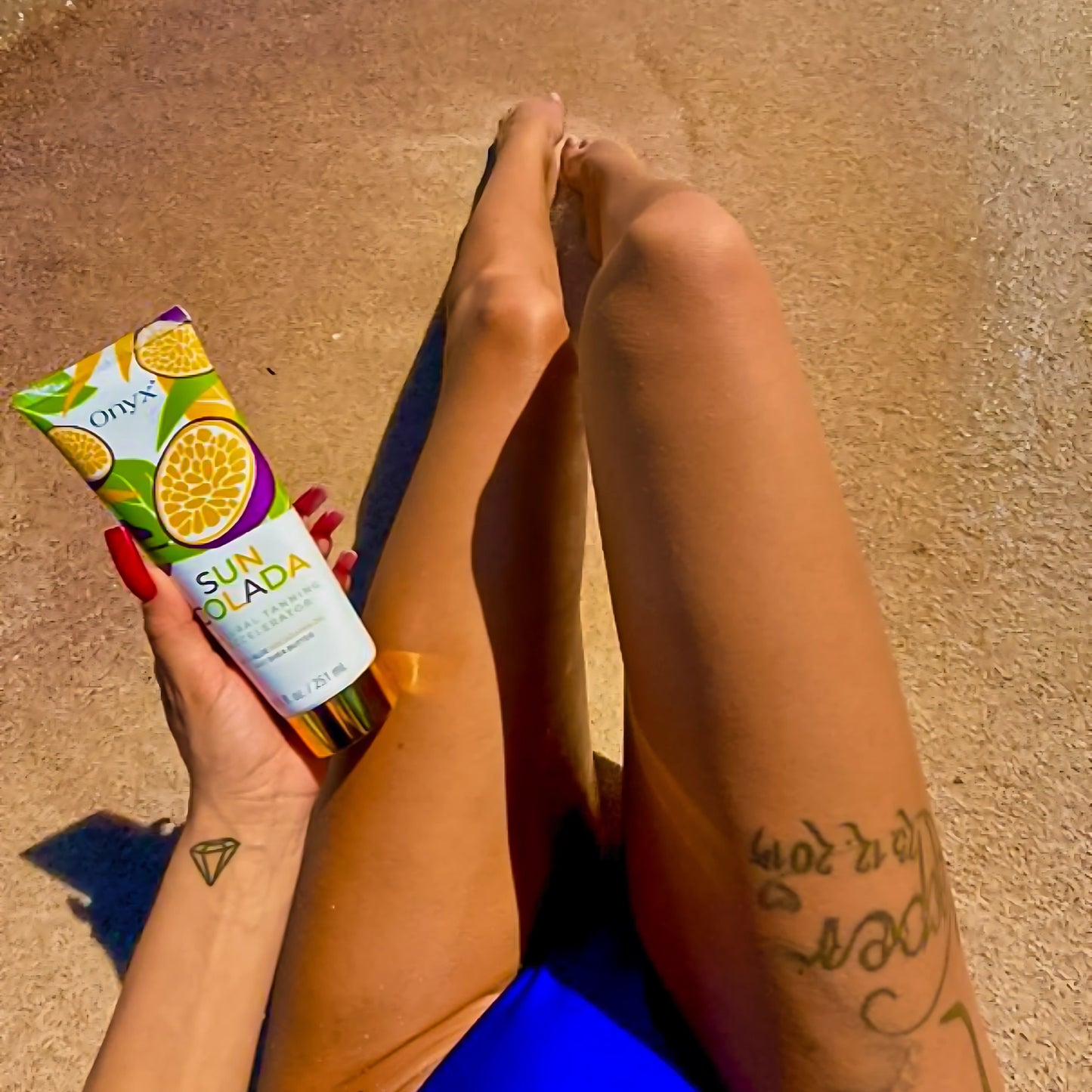 Primer plano de una mujer sosteniendo la loción bronceadora Onyx Suncolada durante la exposición al sol, diseñada para bronceado seguro en cama UV y al sol, con ingredientes naturales y sin bronceador