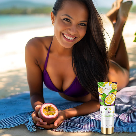 Mujer sonriendo en la playa con el acelerador de bronceado Onyx Suncolada y fruta de la pasión, enriquecido con aceite de macadamia y manteca de karité para bronceado natural en cama solar y al aire libre
