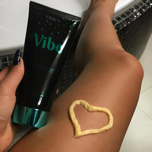 Primer plano de una pierna con loción bronceadora aplicada en forma de corazón – Onyx Vibe garantiza un bronceado uniforme y cuidado en cada aplicación