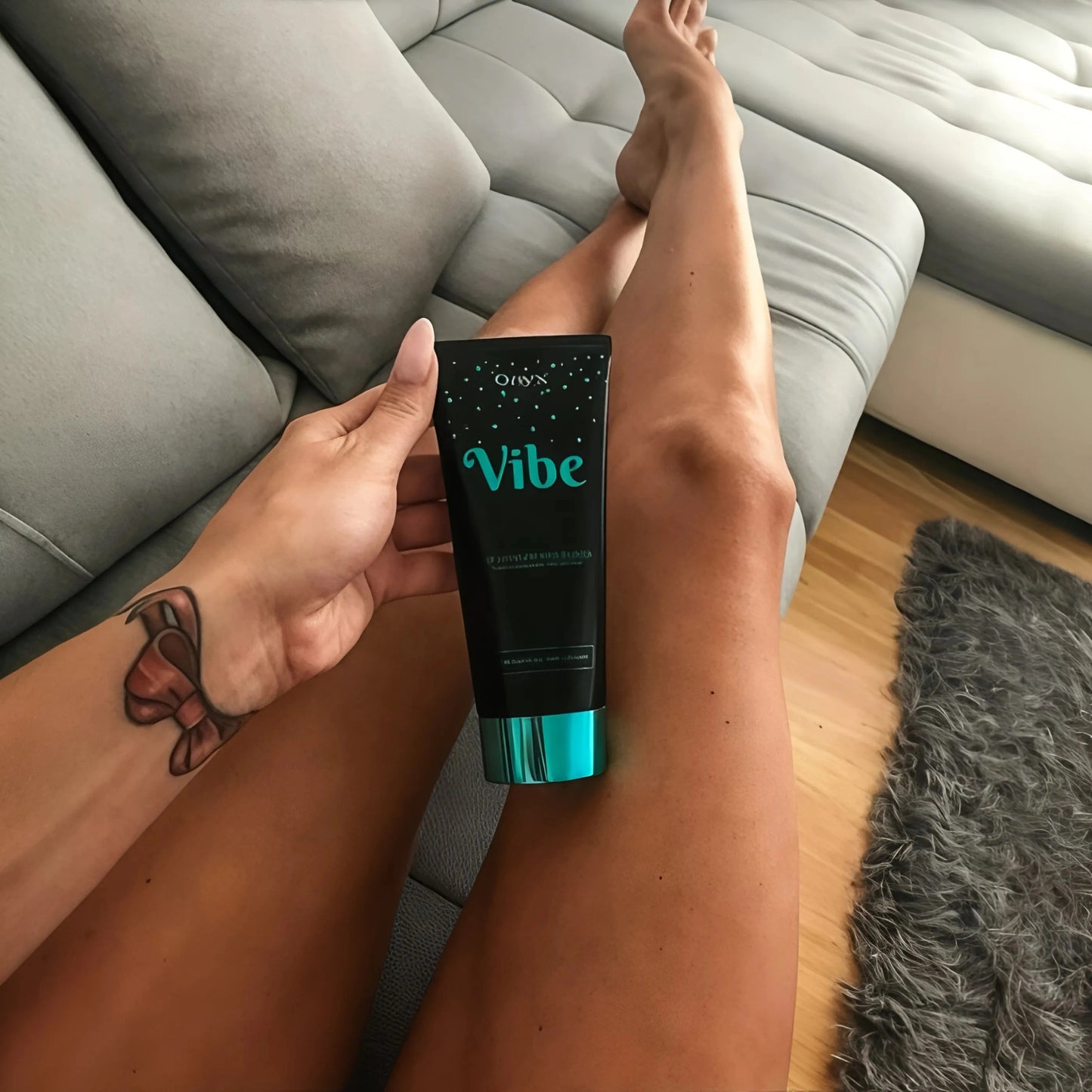Imagen relajada de una mujer con piernas bronceadas y la Loción Onyx Vibe en el sofá – piel visiblemente suave y bronceada con look veraniego