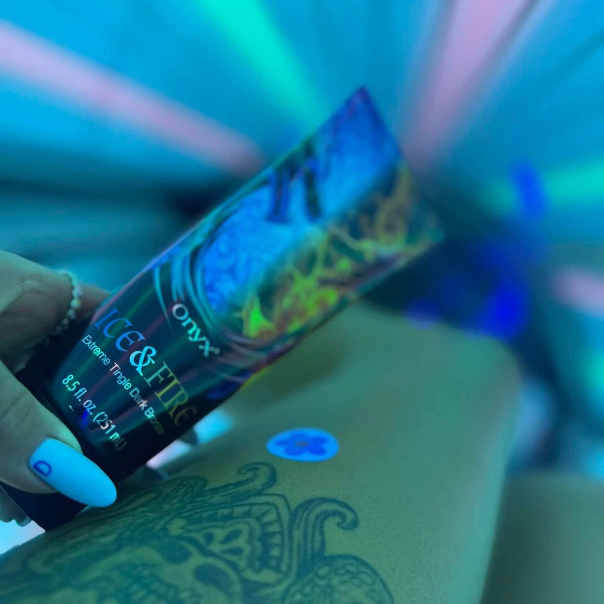 Ice & Fire loción bronceadora en pierna tatuada durante sesión de solarium