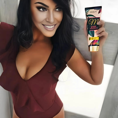 Mujer morena sostiene la Loción Bronceadora Onyx Mystery en la mano y posa con elegante ropa roja