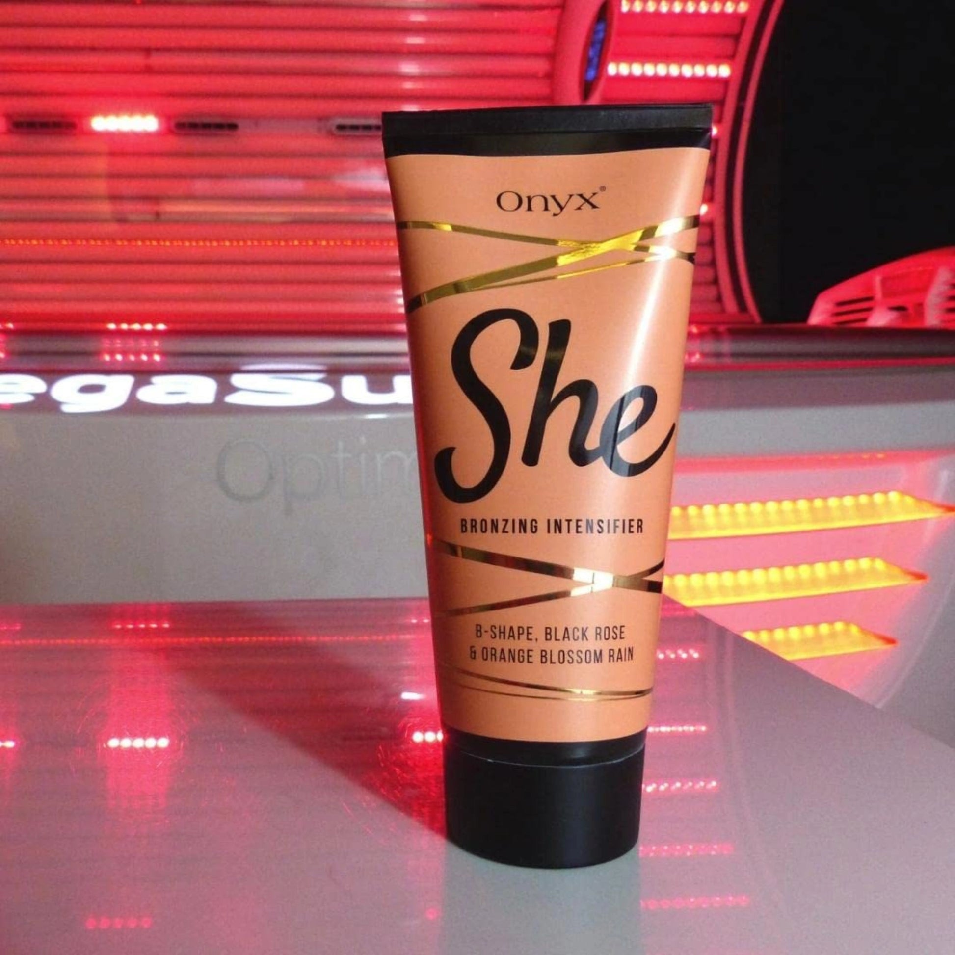 Mujer rubia en la cama con Onyx She Lotion a su lado, muestra piernas cuidadas y bronceadas – loción bronceadora con toque sensual para el hogar