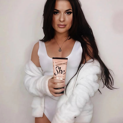 Mujer elegante en bikini blanco disfruta de una bebida en la terraza con Onyx She Lotion sobre la mesa – bronceado lujoso para momentos soleados
